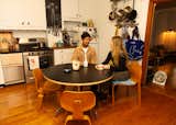 Gerald and Kate in the kitchen with a small subsection of their seating collection, from two Eames chairs to the shibori cushioned Peter Danko. "I was on the fence about that one, but I'm kind of a denim guy, so it also makes sense," he says of the latter. The kitchen table was fused from an Eames base and a laminate tabletop that a friend made. 
