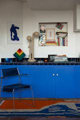 Backdrop's Blue Is the Warmest Color was the perfect electric hue to brighten up this storage area. The rug is custom-made on Etsy, the chrome chair is vintage in the style of Tomado, the lighting is by Entler, and the print is by Richard Kilroy. V<span style="font-family: Theinhardt, -apple-system, BlinkMacSystemFont, &quot;Segoe UI&quot;, Roboto, Oxygen-Sans, Ubuntu, Cantarell, &quot;Helvetica Neue&quot;, sans-serif;">intage Kurt Naef stacking toys from Thomas' childhood have been repurposed as art in the corner. </span>