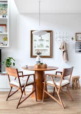 The living room is integrated into the kitchen and has two main environments that merge: the sofa and the dining table.

In this living room and kitchen space, the rack was created to have multiple purposes, serving as a trunk for storing objects, as a shelf for the television and as a bench for the table.

The table can be used for meals, comfortably accommodating four people, as well as to be a workspace on home office days.

The round dining table is made with Cumaru natural wood veneer, it comes with two chairs made of the same wood made by brazilian product designer Paulo Alves and the extra seats on a long bench that is also used as a TV rack.
The pendant lamp over the table is SANN 02, by product design studio HOSTINS—BORGES.