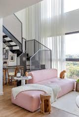 The sofa is the highlight of the living room and the choice for the light pink color was precisely to balance the light tones of the project, accompany the light wood floor and bring personality to the environment — also, it was one of Carla's dreams for this apartment.
