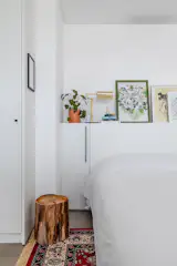 The headboard is a shelf space that occupies paintings, lamps and personal objects.
Under the bed is a Persian-style red rug, which gives more comfort and warmth to the environment, which has a gray ceramic floor.
