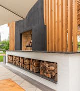 Built-in wood storage below the double sided dyed stucco fireplace 