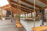 The portion of the pergola over the outdoor kitchen is fully covered with a tongue and groove ceiling featuring recessed lighting and a ceiling fan 