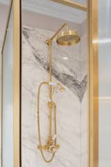 Elegant yet practical, the brass finished shower against the marble slabs is very inviting 