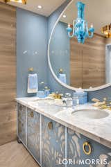 Lori takes a decisive turn with the colour palette when it comes to designing the spa. Pastel blues, billowy whites and soft wood tones create a sense of serene sophistication in this custom oasis, from the floral motifs on the vanity and shower doors to the abundant storage discreetly concealed by high gloss lacquer cabinetry with mirror inserts and brass strapping.