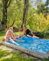 Abigail Lloyd & Bell Kauffman sit with their feet into their plunge pool