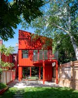 The back of Eva Pianezzola’s Toronto home, designed by Kfir Gluzberg of Kilogram Studio, features a bright red facade that may look a little extreme at first glance, but the color and form of the structure play off the redbrick gabled homes around it.