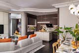 Entering a deeper area of the residence, the merging of the family room, dining, and kitchen creates a seamless impression of open space.