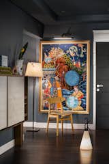The whimsical and contemporary style give strong impressions in the corridor leading to the bedrooms through the selection of dark blue colors and paintings that are deliberately placed at the end of the corridor. The choice of this unusual dark color palette is able to create a calming atmosphere for the owner of the house before taking a break.