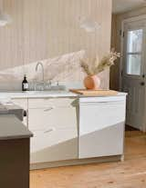 Kitchen, Marble Counter, Pendant Lighting, Stone Slab Backsplashe, Undermount Sink, Light Hardwood Floor, White Cabinet, Dishwasher, Wood Cabinet, Colorful Cabinet, Laminate Cabinet, and Ceiling Lighting  Photo 16 of 18 in Skye cottage by Camille Charland