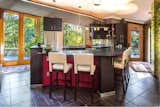 Kitchen, Pendant Lighting, Laminate Cabinet, Granite Counter, Porcelain Tile Floor, Drop In Sink, Ceiling Lighting, and Refrigerator The light-filled kitchen and large island.  Photo 14 of 17 in The Barrett-Tuxford House by William Green