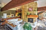 The living room and massive, limestone fireplace with hanging sculptural light fixture.