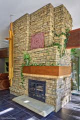 The limestone fireplace with suspended hearth and large mantle.  On the left is a large, sculptural hanging light fixture.