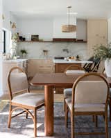 Kitchen with Carrera quartz, pink cabinets, gold hardware, and dining area