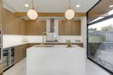 Kitchen with Chic Solid White Quartz counters and waterfall, European flat panel Cabinets 