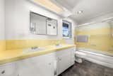 The spacious children's/guest bathroom, replete with original tiles, features original cutting-edge technology -- a ceiling-mounted heat lamp and wall-mounted air purifier.