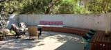 A large curved brick seat carries the mid-century design into the garden