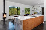 Kitchen, Stone Counter, Cooktops, Ceiling Lighting, Wood Cabinet, and Concrete Floor Kitchen area with Herman Miller chairs and fire place  Photo 9 of 15 in Wander Ashville Meadows by Matt Kowalewski