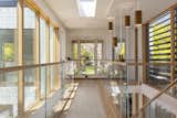 The upstairs offers a view into the upper atrium and leads to the primary suite.