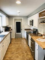 Farmhouse kitchen with oversized sink, under-counter refrigerator drawers, butcher block tops and bar.