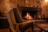 Living Room, Chair, Medium Hardwood Floor, Wall Lighting, and Wood Burning Fireplace Original open fireplace at the heart of the home   Photo 7 of 43 in Tasman Cottage by Nick Green