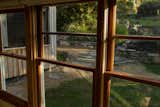 Restored Cedar windows looking out to the stonewall, patio and staircase leading to outdoor bath 
