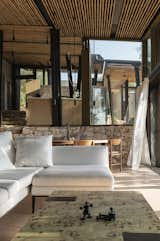 Living Room, Chair, Terrazzo Floor, Ceiling Lighting, Sofa, Coffee Tables, and Table  Photo 18 of 21 in A Cluster of Earthy, Stone-Built Huts Form a Far-Out Retreat in Greece from Meganisi House
