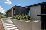 Plywood-formed concrete elements extend from inside to out as the primary retaining material used to terrace up the hill.