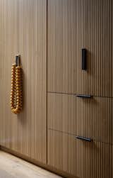 Dark metal hardware on the custom oak cabinetry keeps things streamlined and contemporary in the primary bedroom. 