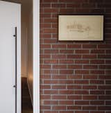 A pivot door in the main hallway separates the bedroom suite from the public areas of the home. An original plan for the house, built in 1959, hangs on the wall.