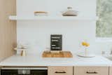 White quartz countertops and white oak cabinetry create a neutral background for kitchen accouterments. The idea of a phoenix rising from the ashes is a mantra that Sammie embraced throughout the renovation.  