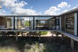 Glassed-in corridors visually connect public spaces in the house while making the surrounding landscape feel like part of the design. 