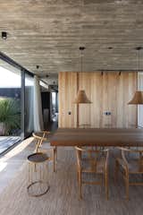 According to Martin, he and Daniela traveled to Indonesia to source furniture for the house. In the dining room, the home's main two materials, wood and concrete, are on full display. Woven pendant lamps and a texture area rug soften the otherwise hard surfaces. 