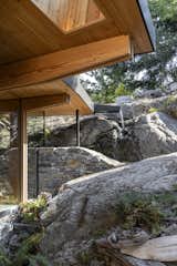 The rock outcropping in the backyard of this house in Victoria, British Columbia influenced the design scheme of the home's addition. To visually integrate the form, architect Bruce Greenway took shorn-off pieces of rock and constructed a curving wall that extends into the house. 