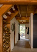 The original A-frame now holds the main living areas, including the kitchen and living room. A stair leads to a lofted bedroom. 