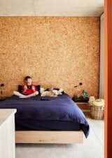 Eleven-year-old Jamie sits on the bed with family dog, Bokkie. All materials chosen for this project have a specific relationship with South Africa and its design vernacular. The cork wall is a nod to the country's indigenous cork bush. 