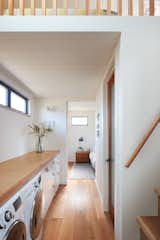The only transitional area in the home is this small hallway, which doubles as storage and laundry room. The primary suite is at the end, and the stairs lead to a loft for the children.  