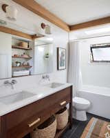 When four people share one bathroom, two sinks are a necessity. To accommodate both basins in the small footprint, Brian commissioned a custom walnut vanity. 