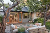A set of French doors serves as the entryway to the home, which opens onto a flagstone patio where the family entertains. 