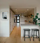 A pocket door at the far end of the kitchen opens to reveal the homeowners' photo studio. Flooring throughout the loft is original; the designers refinished it for an updated appearance. 