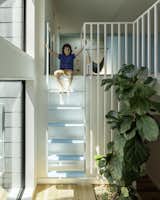 Clark sits at the top of the ladder to his playroom. Emily and Eric purchased the fiddle leaf fig tree when they were dating; it has followed them ever since. Currently, in residence in the connector space, it receives ample amounts of light. "This is a favorite spot in the home," Emily says. "When you pass through here,  you can take a moment to pause and decide where you want to go."