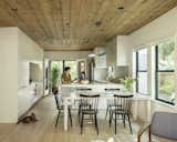 The kitchen and dining areas seamlessly blend through materiality. Original pine ceilings add texture, and sleek, painted MDF cabinetry makes the room feel modern. 