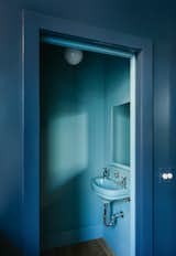 The powder room has a wall-mount sink the couple found at a salvage yard, an American Standard in Regency Blue. Janusz color-matched the paint for the room.