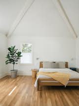 The primary bedroom, which Michelle wanted to be a calming oasis, has a minimal palette of oak wood and white paint. "It's nice to have a private space to read for the first time ever!