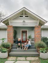 Michelle White, a senior curator at Houston’s Menil Collection, her husband Haden Garrett, and their nine-year-old son Oliver sit on the porch of their Houston Heights home—a Sears kit home built in the 1920s. The couple worked with local studio Janusz Design to add a new two-story section that includes a laundry area, primary suite, and garage. 