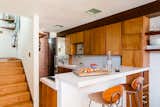 The architects stayed true to the kitchen's original configuration, adding custom shelving  crafted by Timbra, inspired by the geometry of the original cabinetry. 