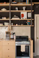 The custom cabinetry is made from white oak, with hardware from Matilda Goad & Co. The open shelving holds pieces with meaning. "A lot of the bowls, plates, trinkets, flatware, some of the lighting and art, were kept from the business our family owned when we sold it, so these pieces are really special," Ben explains. 