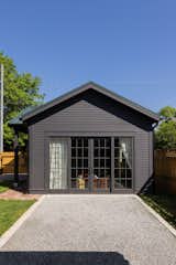 The doors on one side of the DADU's main living space open to the backyard of the main house. The roof and exterior paint were chosen to match the property's existing structure. 