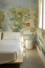 In the bedroom, an Avocado Green organic mattress sits on a simple Floyd bed frame, leaving the Anthropologie mural wallpaper as the standout element. Vintage French sconces from a local antique shop flank the bed. 