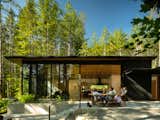 A simple, hardscaped back patio is the site of many summer parties. The steps lead down to the firepit, where one feels increasingly embraced by the forest. 